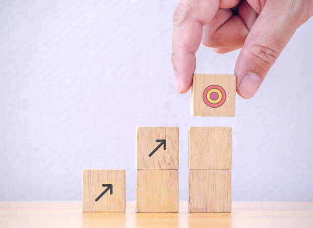 istock Businessman putting to arranging wood cube with arrow stacking step stair to objective target. Business achievement goal and growth success objective concept. 1313309700