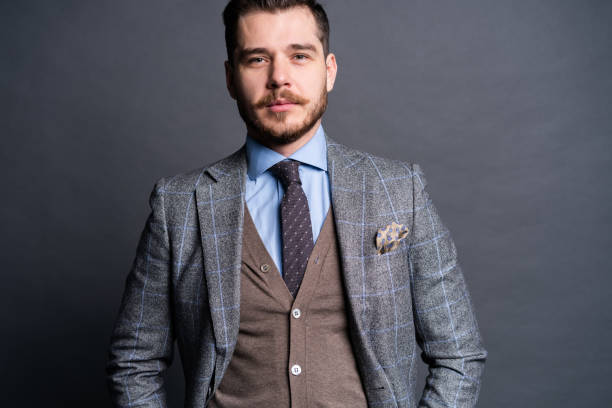 istock A confident elegant handsome young man standing in front of a grey background in a studio wearing a nice suit. 1313309964