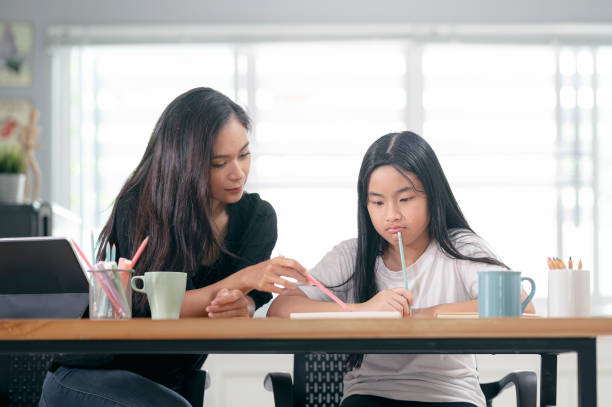 istock mother and child daughter doing homework together. 1313311054