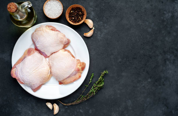 istock Raw chicken thighs with spices on a stone background 1313312026