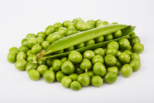 Fresh green pea pods and seeds on white background