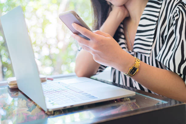 istock Hand woman using a telephone, smart phone and computer laptop in cafe. 1313313247