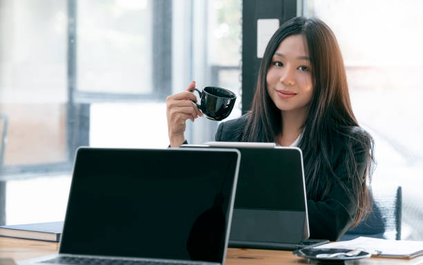 istock Businesswoman holding coffee cup while relaxing during work. 1313313637