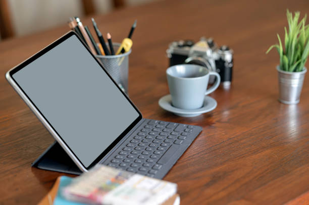 istock Mockup blank screen tablet with keyboard on old wooden table. 1313313736
