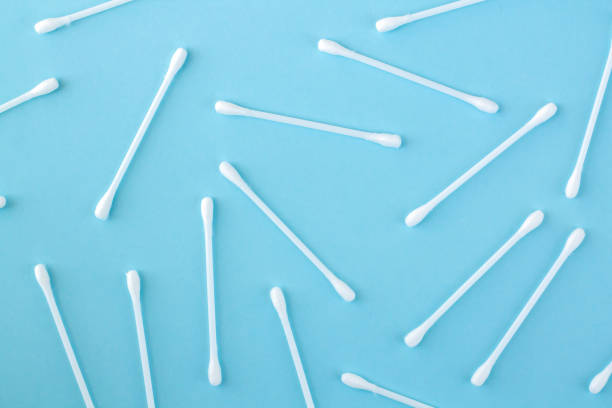 istock Pattern of white plastic cotton swabs or sticks top view on blue background 1313314597