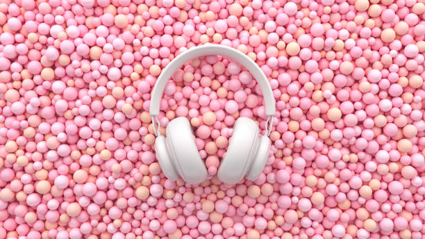 A white headphone on soft pink balls. Minimal musical flat lay concept. Advertisement ASMR idea. 3d render