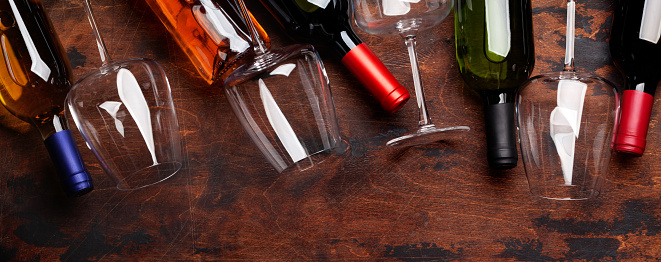 Various wine bottles and glasses on wooden table. Top view flat lay