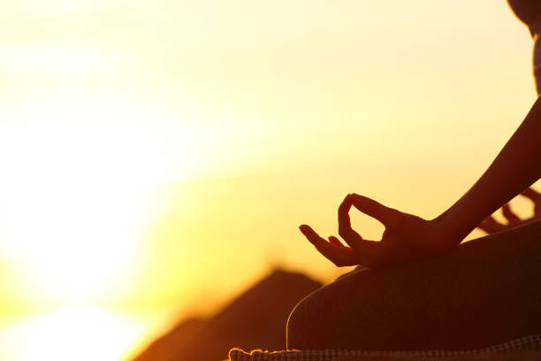 istock Woman hand silhouette doing yoga at sunset 1313316425