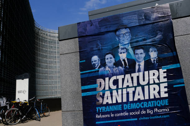 un cartel de movimiento anti-vax frente al edificio berlaymont, la sede de la comisión europea en el distrito europeo de bruselas, bélgica, el 19 de abril de 2021. - president of france fotografías e imágenes de stock