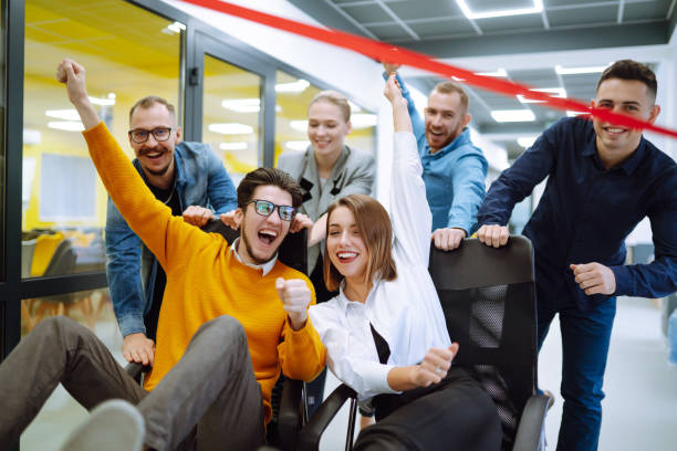 istock Friendly work team  ride chairs in office room cheerfully excited diverse employees laugh while enjoying fun work break activities, creative friendly workers play a game together. 1313318144