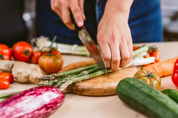 istock preparing fresh asparagus meal on wood chopping board preparing in kitchen with fresh vegetables. concept of spring diet and organic vegan nutrition 1313318278