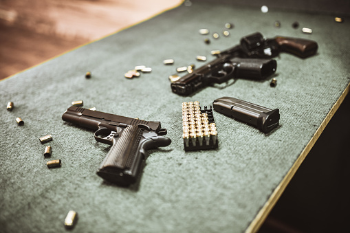 Pistolas modernas y cartuchos de pistola en el campo de entrenamiento de armas photo
