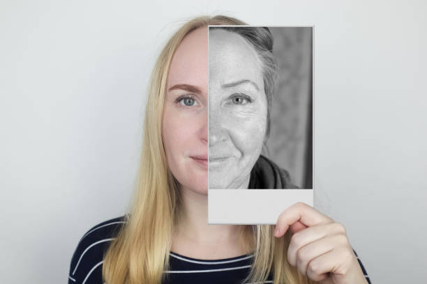 la niña sostiene una fotografía de su antigua madre en la cara. envejecimiento, genética, árbol genealógico y pérdida de concepto juvenil. antes y después de los cambios relacionados con la edad. fotograf�ías vintage. - family tree family photograph photography fotografías e imágenes de stock