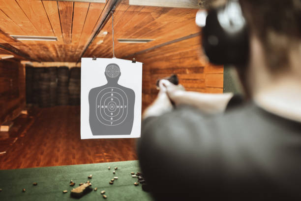 сосредоточенный мужчина пытается забить высоко на пушки практикующий диапазон - target shooting стоковые фото и и�зображения