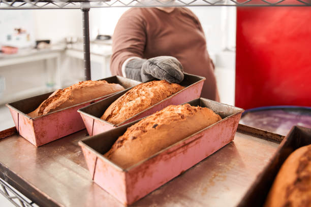 istock Male worker putting cakes in bakeware on tray on a bakery trolley 1313320769