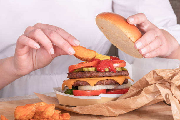 istock Hand dipping a potato slice on juicy burger sauces 1313320777