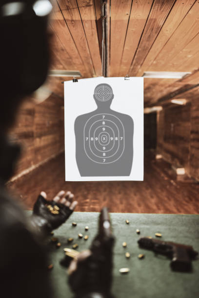 istock Male Counting Bullets Shot At Empty Target On Gun Range 1313320798