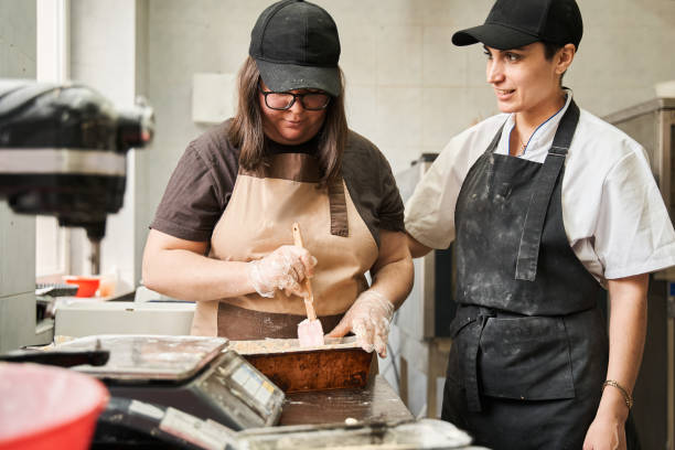 istock Cook standing at her kitchen table with her assistant and discussing future cake 1313320809