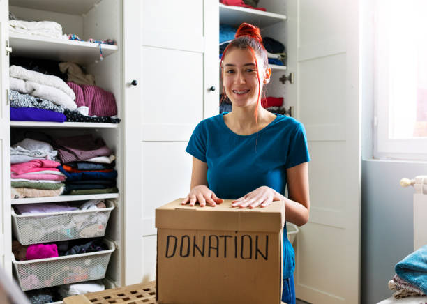 istock Young woman sorting clothes for donation 1313321168