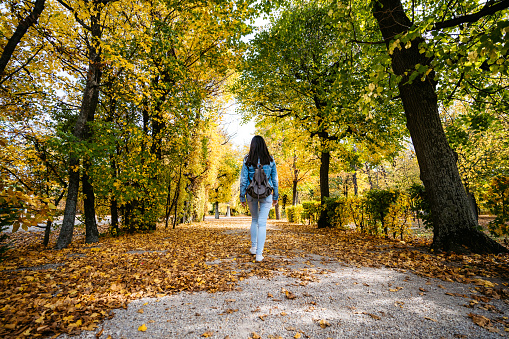 Young cute Caucasian woman walking in a park in Vienna. Autumn time.