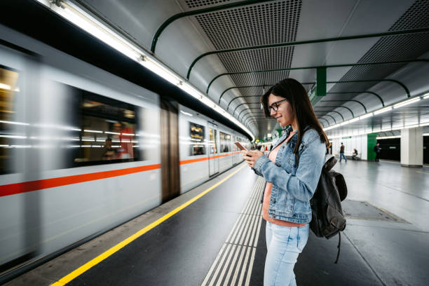 istock Woman playing game on phone at subway station 1313325006