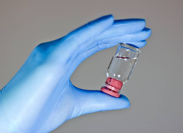 Glove, mask, syringes and an antiseptic, in a hand packed different pills, Doctor filling syringe for COVID-19 Vaccine