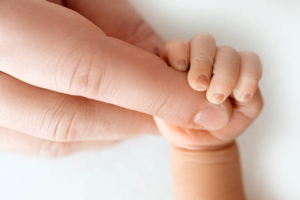 istock Newborn baby holds mom's finger tightly. 1313325581