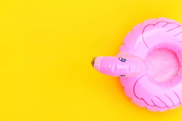 istock Summer beach composition. Simply minimal design with pink Inflatable flamingo isolated on yellow background. Pool float party, trendy celebrity fashion concept. Flat lay top view copy space 1313327064