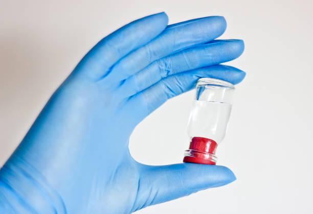 Glove, mask, syringes and an antiseptic, in a hand packed different pills, Doctor filling syringe for COVID-19 Vaccine