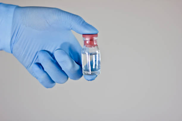 Glove, mask, syringes and an antiseptic, in a hand packed different pills, Doctor filling syringe for COVID-19 Vaccine