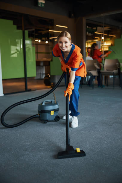 istock Smiling pretty cleaning lady vacuuming the floor 1313329744