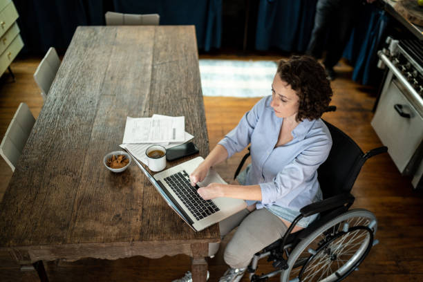 집에서 일하는 노트북을 사용하는 장애 여성 - working people physical impairment wheelchair 뉴스 사진 이미지