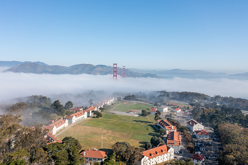 Aerial View of the Presidio with fog billowing over the Golden Gate Bridge.
Sunny blue sky with fog rolling over the bridge.