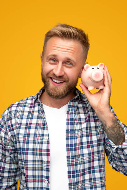 istock Happy man shaking piggy bank 1313330932