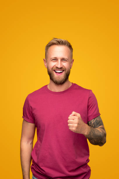 Energetic hipster man with tattoos looking at camera