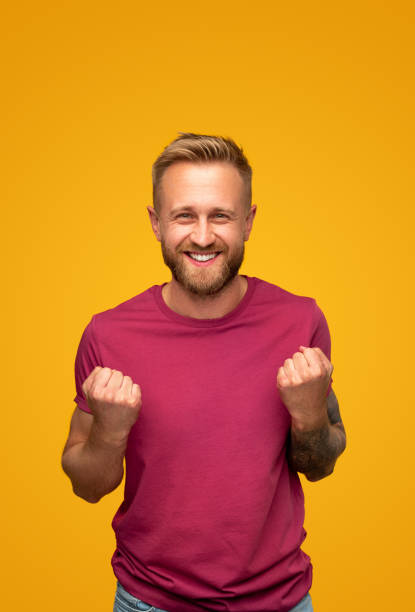 istock Excited man clenching fists and smiling at camera 1313330971