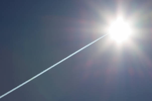 vols d’avion laissant la trace de contrail avec un soleil lumineux dans le ciel - avion supersonique photos et images de collection