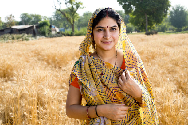 mujer feliz de pie en el campo agrícola - indian culture women india indian ethnicity fotografías e imágenes de stock