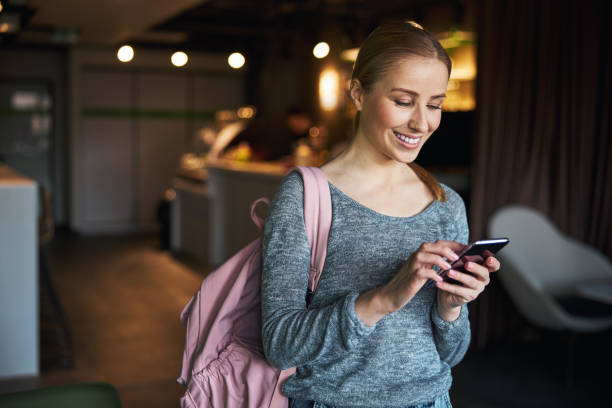 istock Smiling blonde lady surfing the Internet using her gadget 1313333050