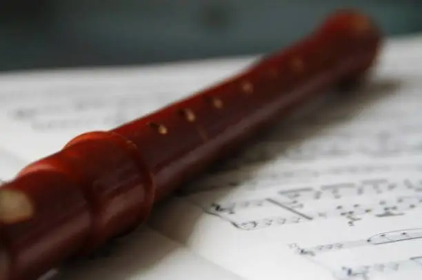 the block-flute lies on the sheet of music