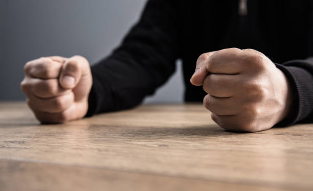 istock man fists on a wooden table 1313337399