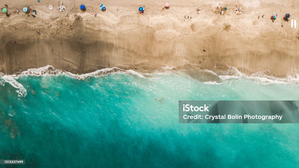 Direct Aerial Overview of a Vibrant Teal Ocean Seashore and Colorful Beach Umbrellas on Jupiter, Florida at Mid-Day During COVID-19 in April of 2021 Aerial Views of Colorful Beach Umbrellas on Jupiter Beach, Florida at Mid-Day During COVID-19 in April of 2021 Florida - US State Stock Photo