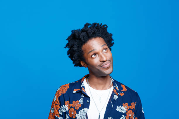 istock Surprised young man in hawaiian shirt against blue background 1313337572