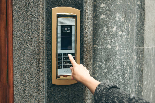 A female hand presses the buttons on the intercom