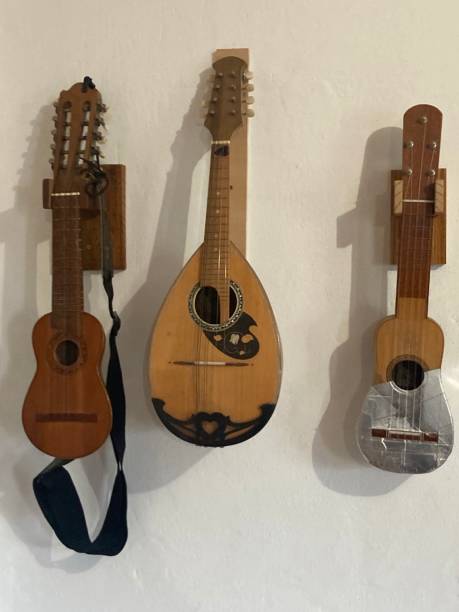 istock Two ukuleles and a bandurria hanging on the wall 1313338255