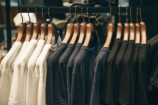 Different or choice of t-shirts on hangers hang in a row.