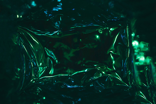 Abstract holographic background in dark green or emerald color