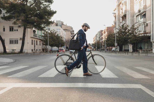 Crossing the Street with the bicycle stock photo Young stylish businessman going to work by bike in the city zebra crossing photos stock pictures, royalty-free photos & images