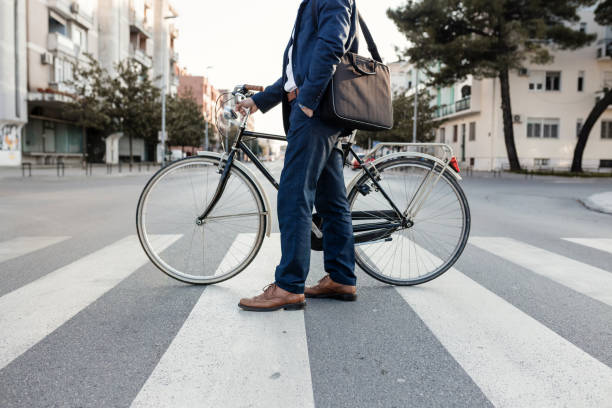 Crossing the Street with the bicycle stock photo Young stylish businessman going to work by bike in the city shoulder bag stock pictures, royalty-free photos & images