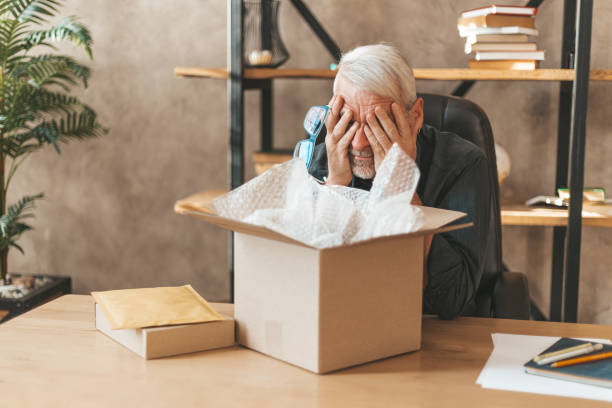 istock Damaged package. The elderly man at the table at home closed his eyes, broken goods. Postal delivery insurance 1313345666